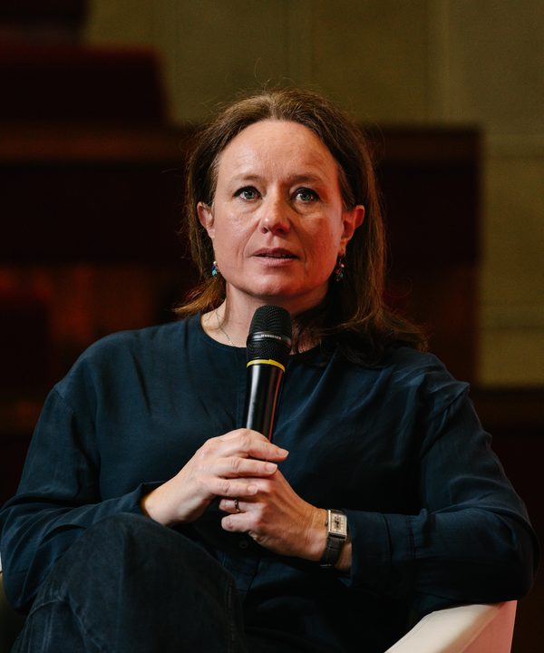 Catherine Bros speaking on a panel, microphone in hand